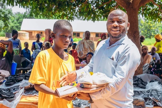 Takara-Bigiza-donates-learning-materials-inset-Mr.-Sandoo-right-presenting-the-items-to-Master-Musah-a-beneficiary-pupil-at-the-school
